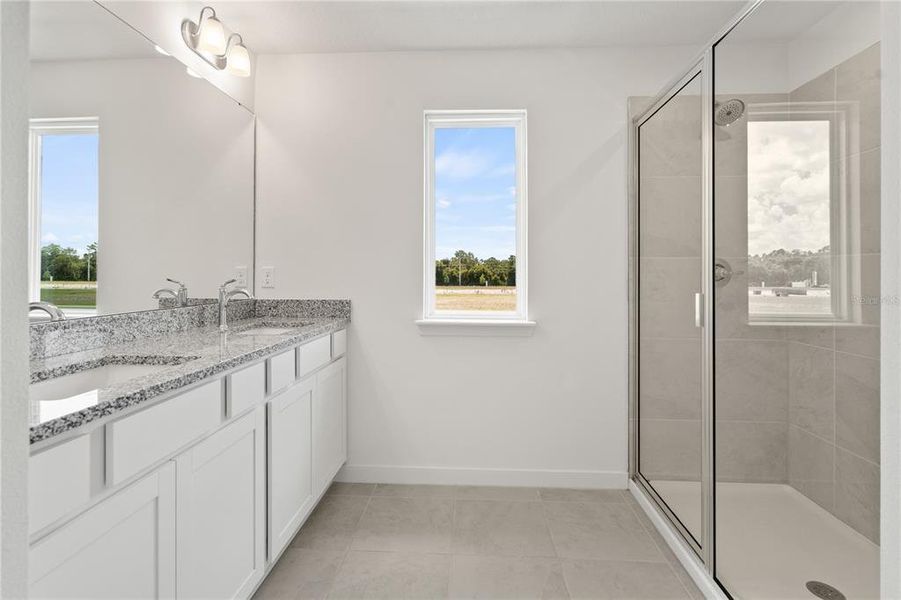 Spacious primary bathroom with dual vanity and lots of light.