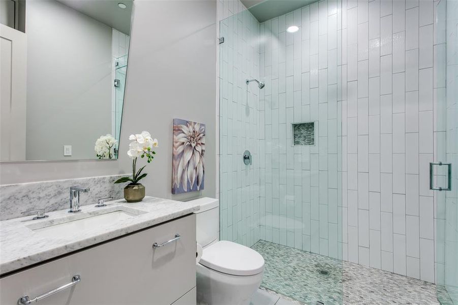 Bathroom featuring tile patterned floors, vanity, an enclosed shower, and toilet