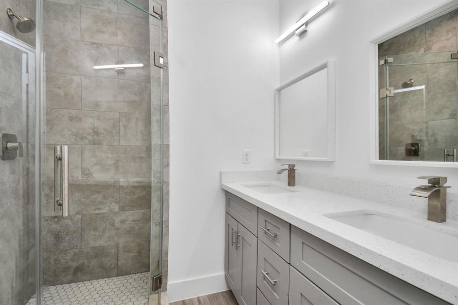 Primary bathroom with double vanity and stand up shower.