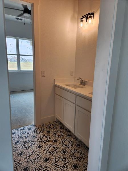 Bathroom featuring vanity, tile patterned flooring, and ceiling fan