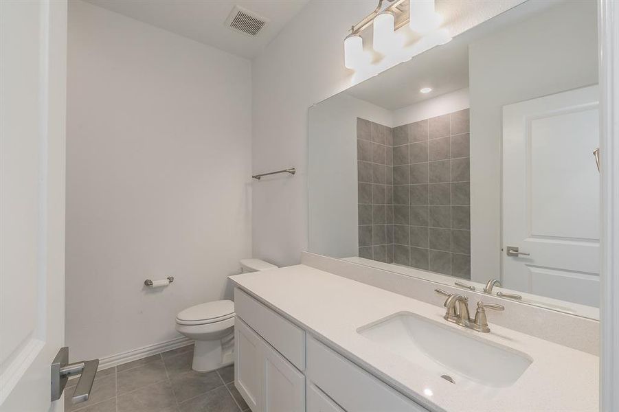 Bathroom featuring vanity, toilet, and tile patterned floors