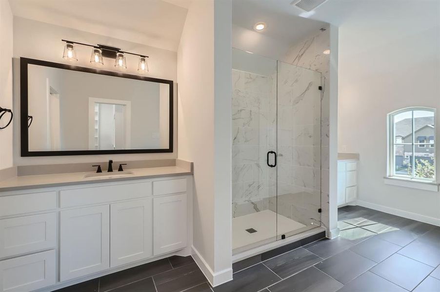 Bathroom with vanity and a shower with shower door