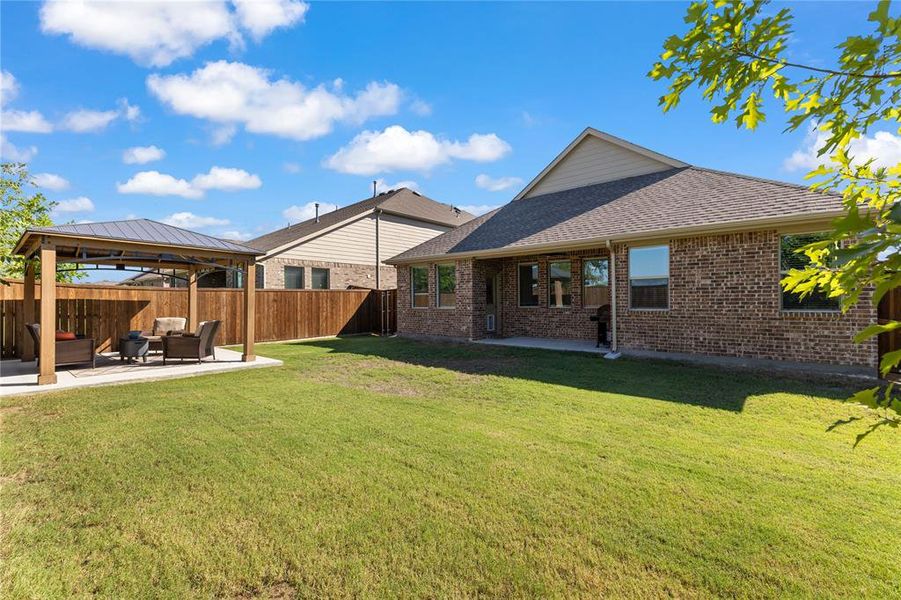 Rear view of property featuring an outdoor living space, a gazebo, a yard, and a patio