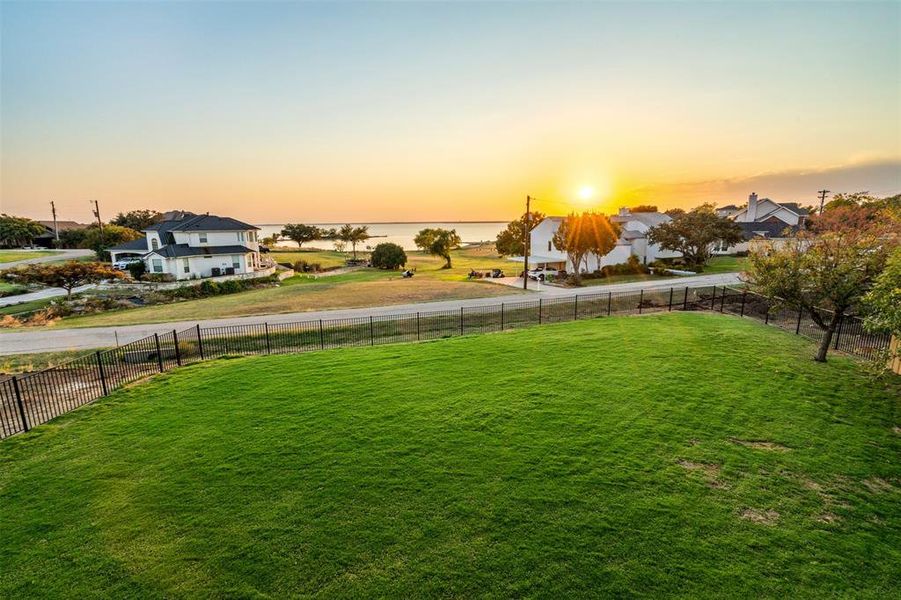 Yard at dusk featuring a water view