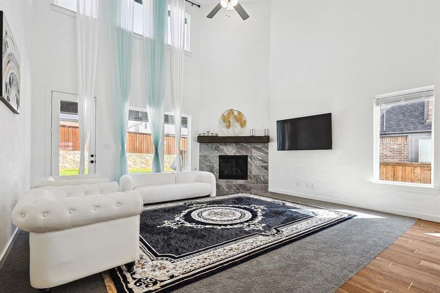 Living room featuring a high ceiling, a wealth of natural light, and light hardwood / wood-style floors