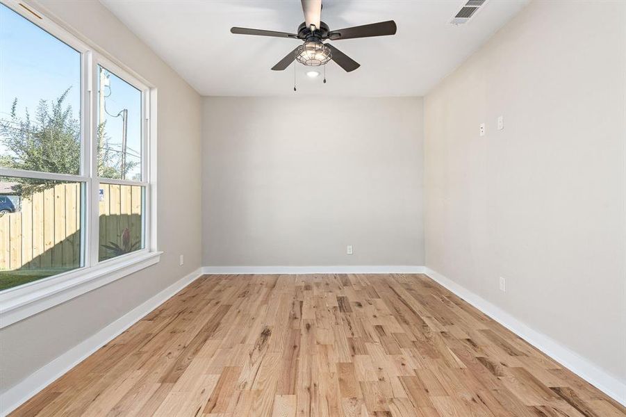 Empty room with light wood-type flooring and ceiling fan