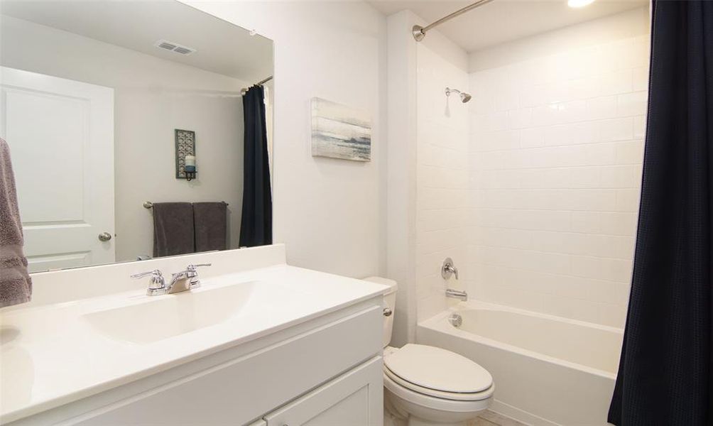 Full bathroom featuring shower / bath combo with shower curtain, toilet, and vanity