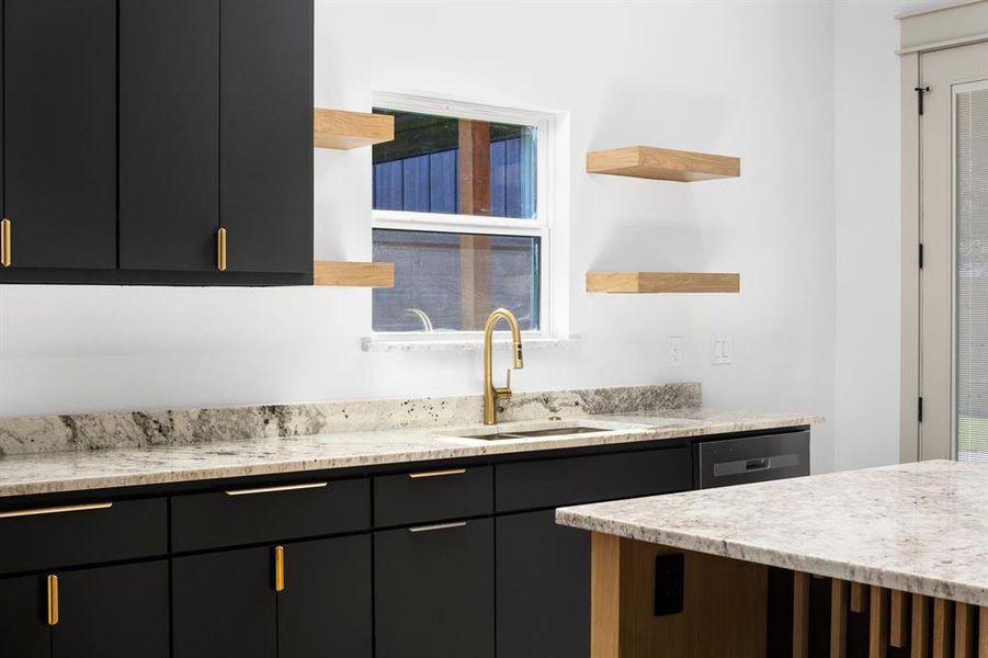 Kitchen with light stone countertops, stainless steel dishwasher, a healthy amount of sunlight, and sink