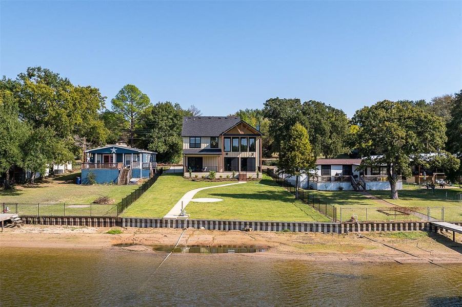 Back of house featuring a yard and a water view