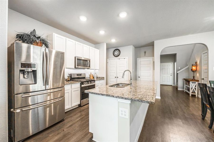 Lovely open kitchen featuring undercabinet lighting, gas range, built-in microwave, granite counters and a large double door pantry! Great island with space for barstools!