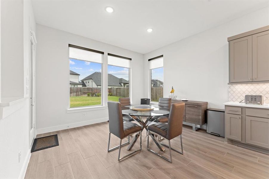 Adjacent to the kitchen, the breakfast area is flooded with natural light and conveniently located near the backyard access.