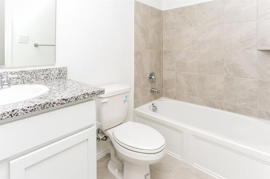 Bathroom with tile patterned floors, vanity, and toilet