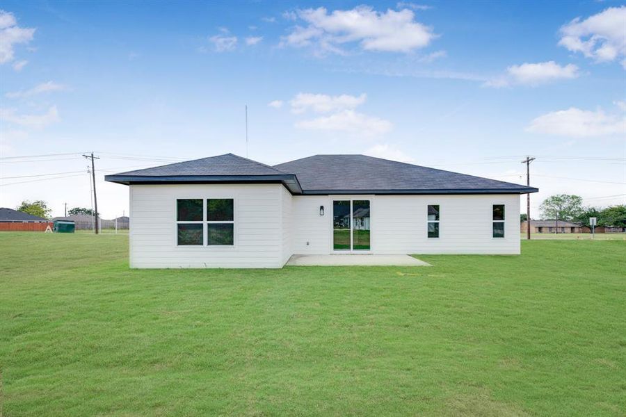 Back of house with a yard and a patio