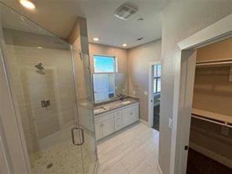 Bathroom with vanity and a shower with shower door