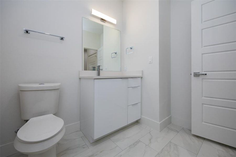 Bathroom featuring tile flooring, vanity, and toilet