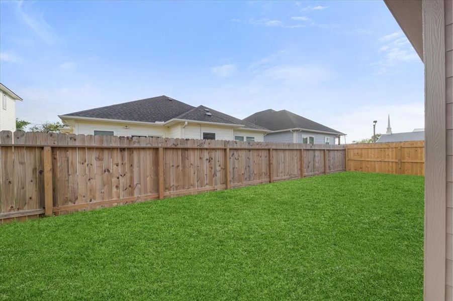 Your expansive, fully enclosed backyard features a covered patio and plenty of green space.