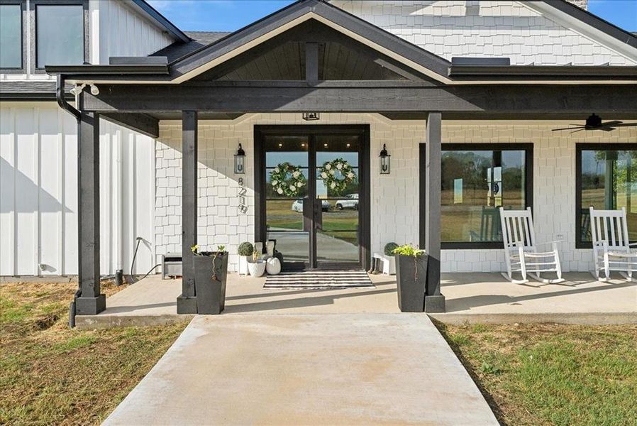 View of exterior entry with ceiling fan and covered porch