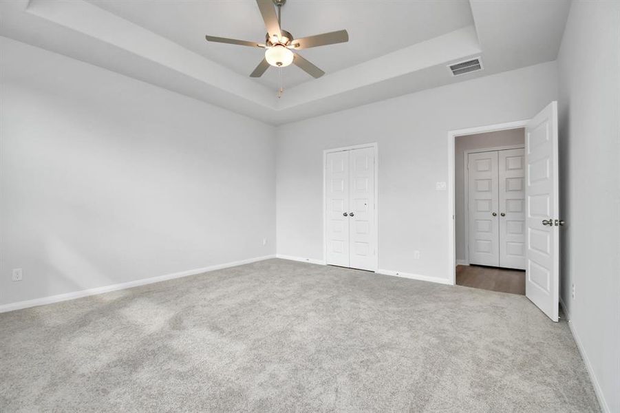 Get ready to relax in this bright and spacious primary bedroom, featuring large windows that allow plenty of natural light to flood the room. The soft, plush carpet adds a cozy and inviting feel underfoot, while the neutral color palette creates a calm, relaxing atmosphere. The room is elegantly finished with a stylish ceiling fan that complements the modern aesthetic and provides both functionality and comfort.