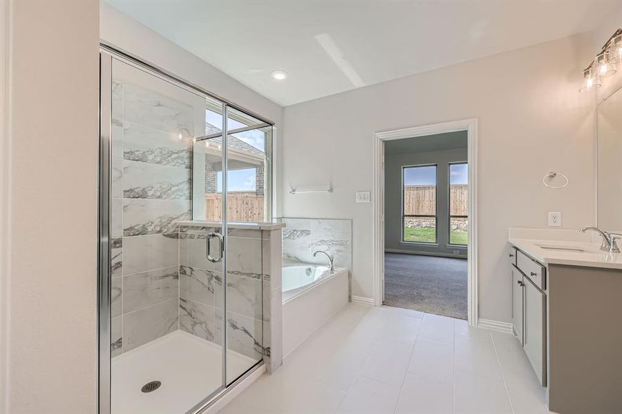 Primary bathroom featuring vanity, plus walk in shower, and tile patterned floors