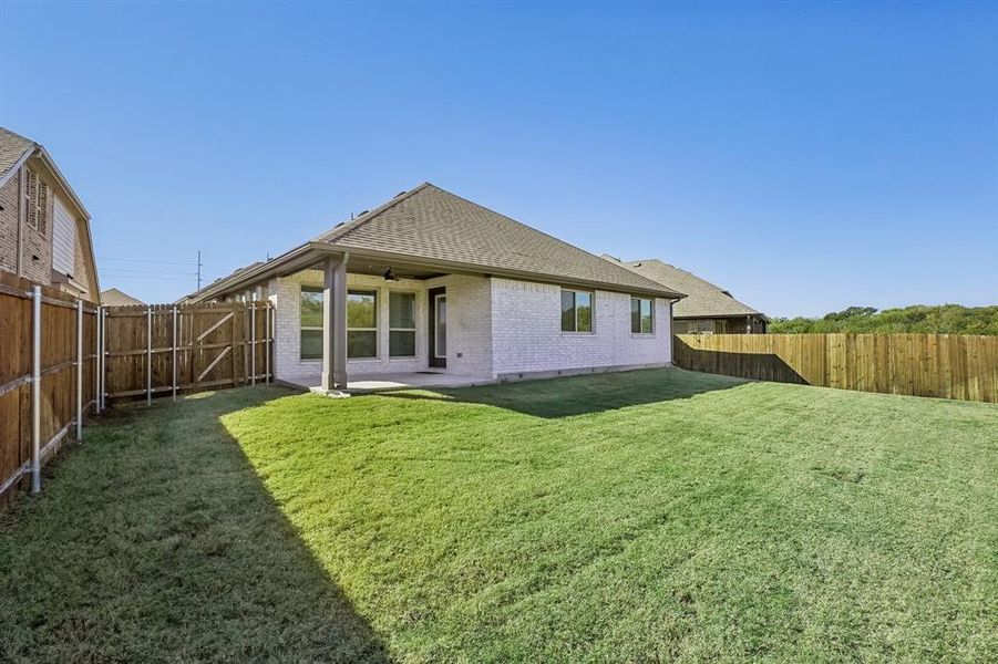 Rear view of property featuring a patio and a spacious yard