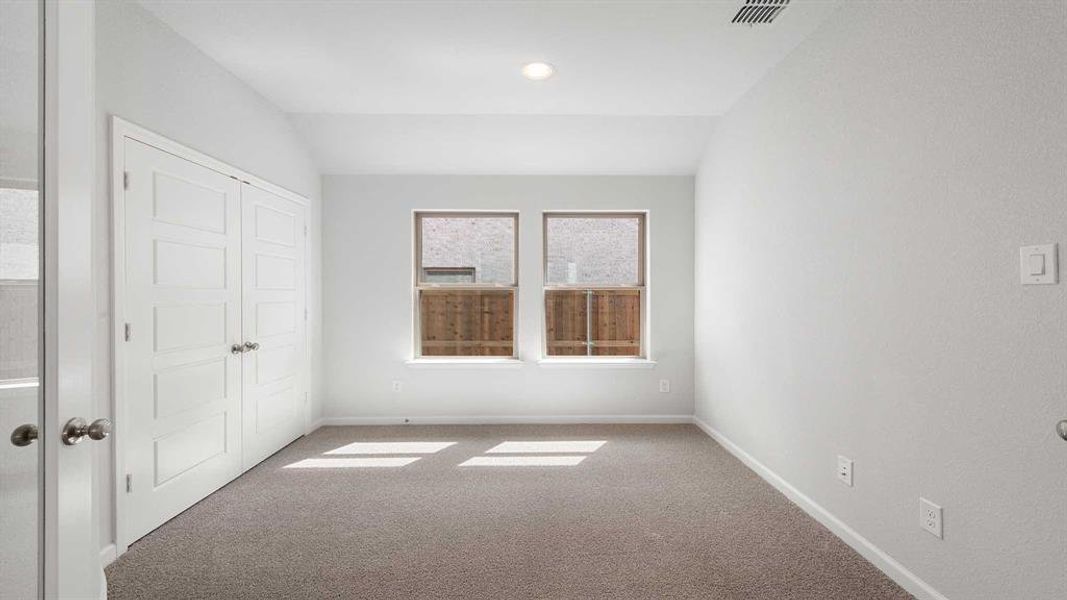 Unfurnished room with carpet and vaulted ceiling