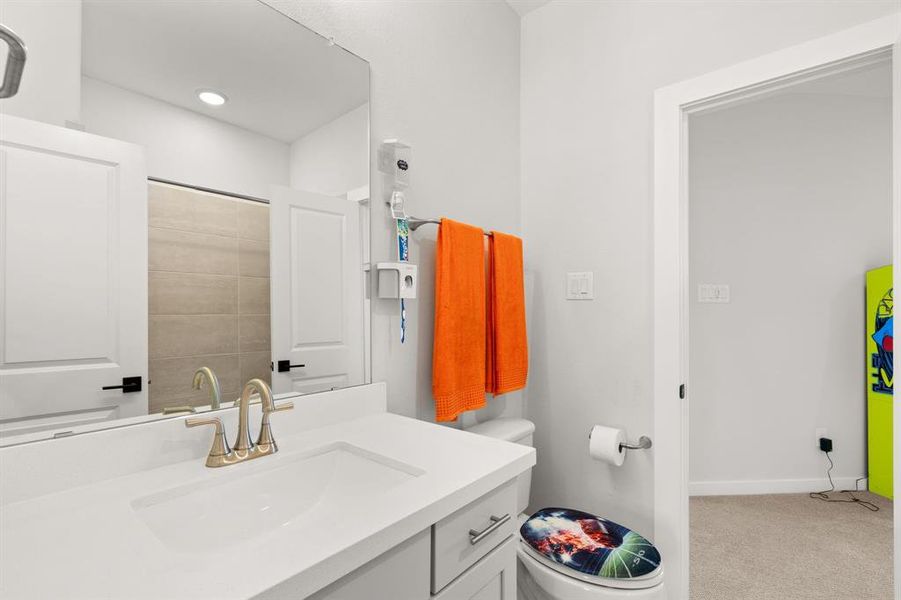 The third bedroom's bathroom boasts two entryways, a tiled shower/tub combo, and a sink vanity, enhancing accessibility and functionality.