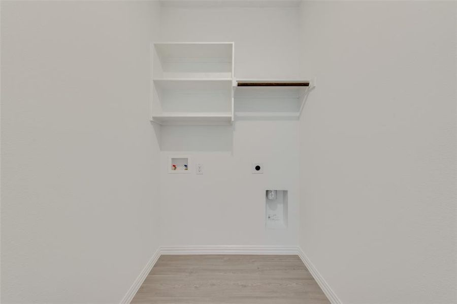 Laundry room with washer hookup, electric dryer hookup, and light wood-type flooring