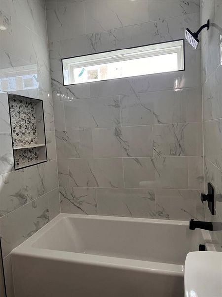 Bathroom featuring toilet and tiled shower / bath