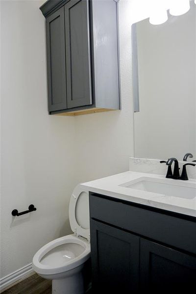 Bathroom featuring hardwood / wood-style floors, vanity, and toilet