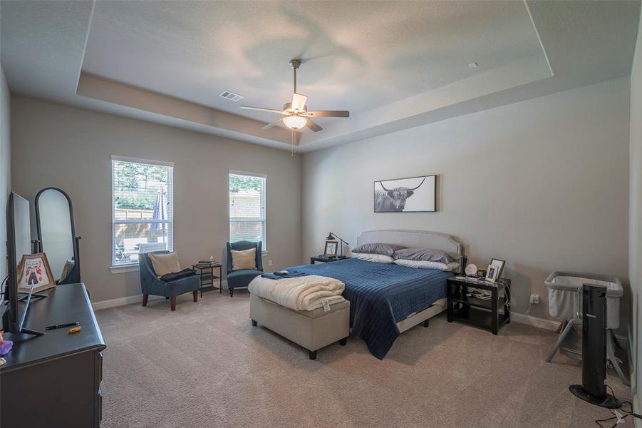 The primary suite is secluded featuring a coffered ceiling and ceiling fan.