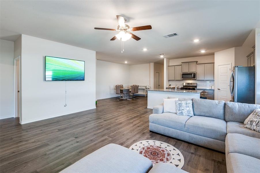 Living room featuring dark wood-type flooring and ceiling fan