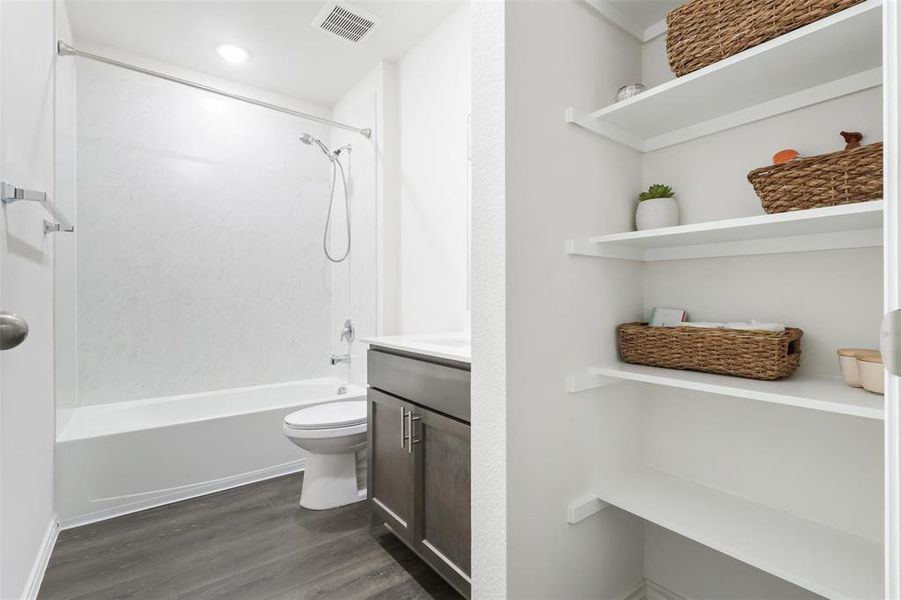 Full bathroom with hardwood / wood-style flooring, vanity, toilet, and bathtub / shower combination