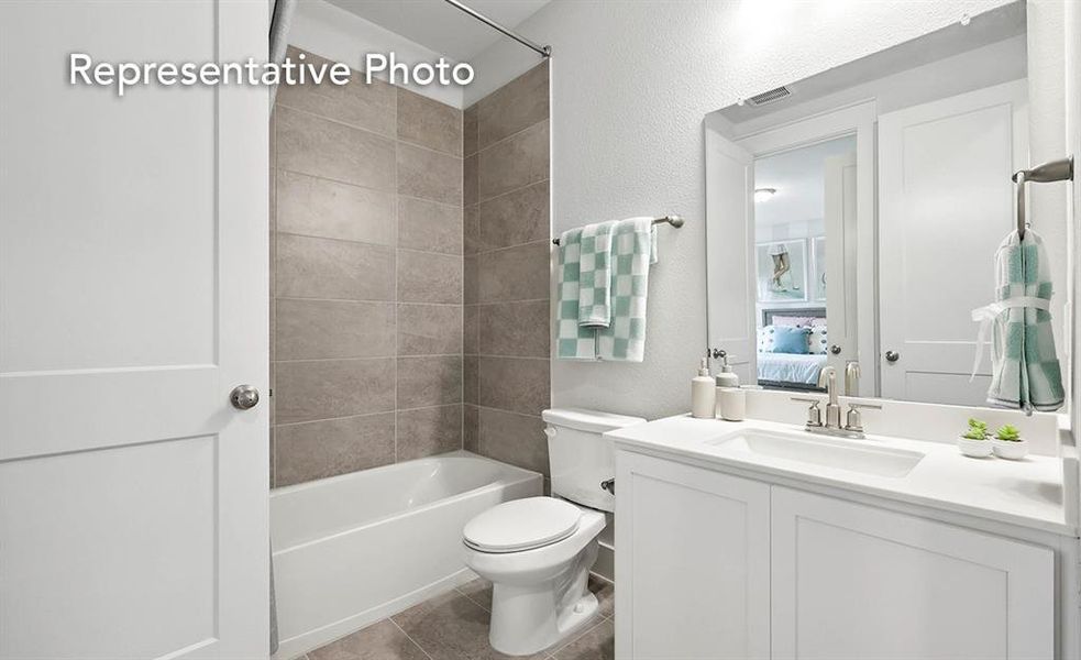 Full bathroom featuring tile patterned floors, toilet, tiled shower / bath, and vanity