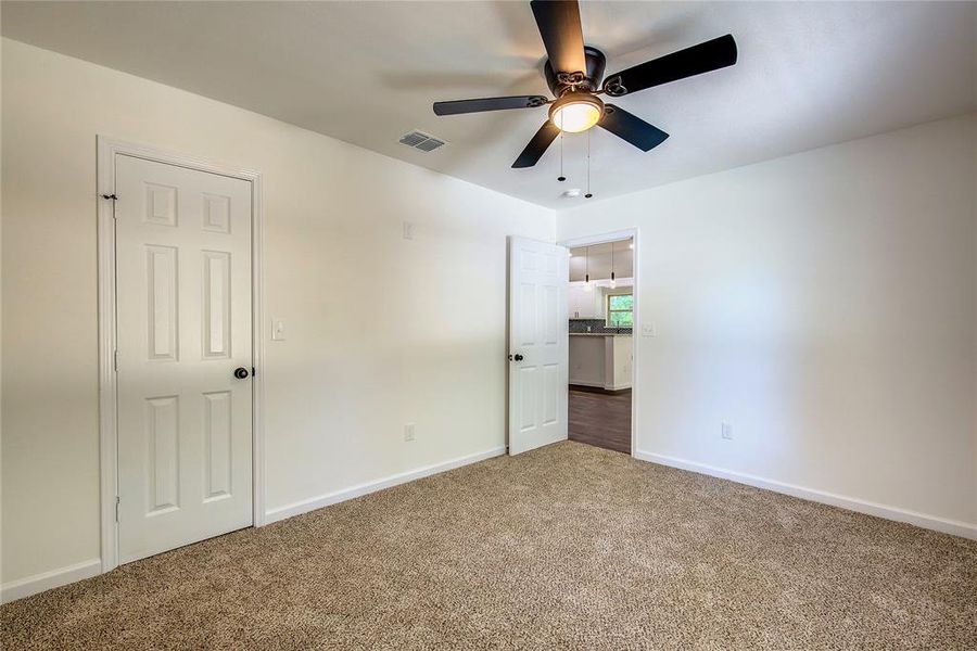 Second bedroom featuring dark colored carpet and ceiling fan