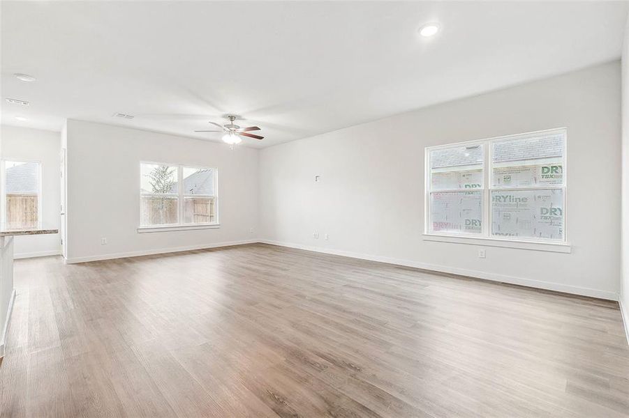 Unfurnished living room with light wood-type flooring and ceiling fan