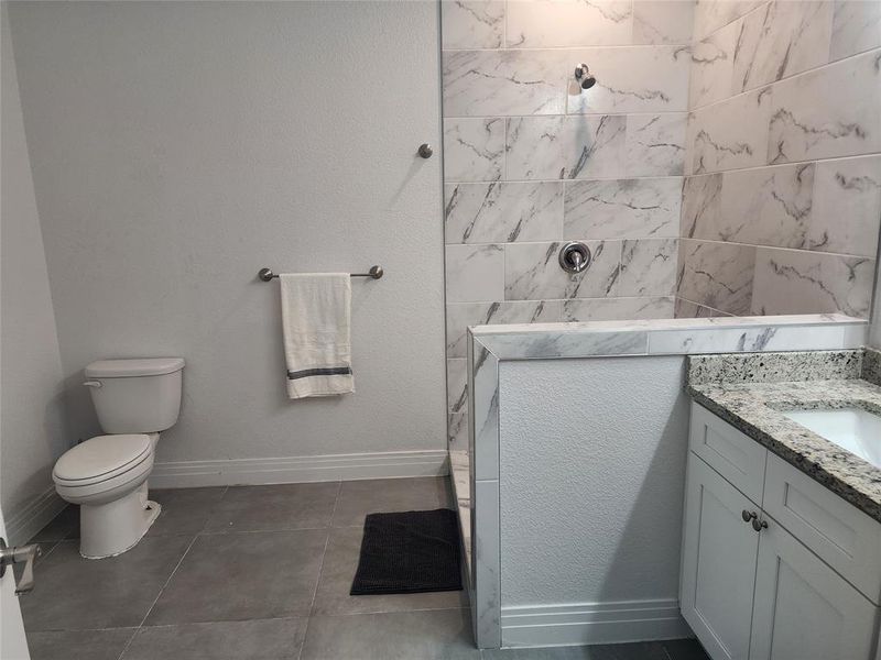 Bathroom featuring vanity, toilet, and tile patterned flooring