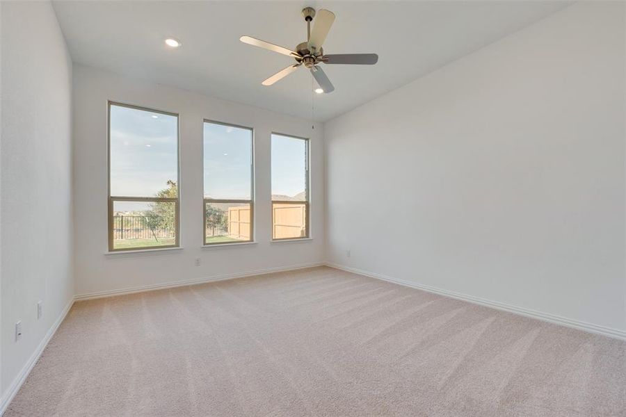 Carpeted empty room with ceiling fan