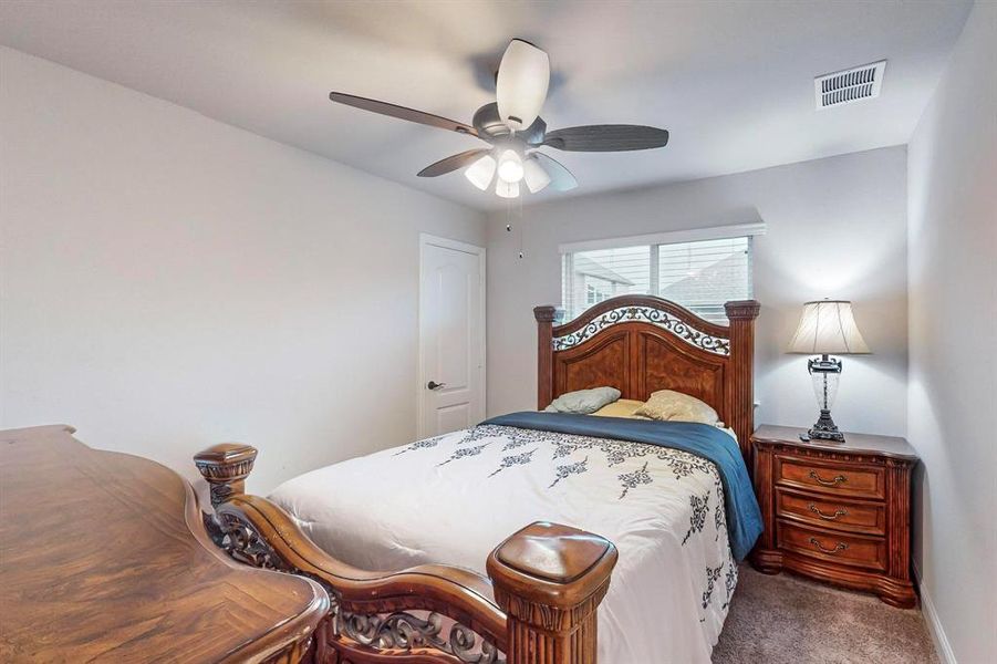 Carpeted bedroom featuring ceiling fan