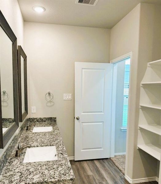 Double sinks in the en suite master bath + linen shelves, granite counters & framed mirrors!