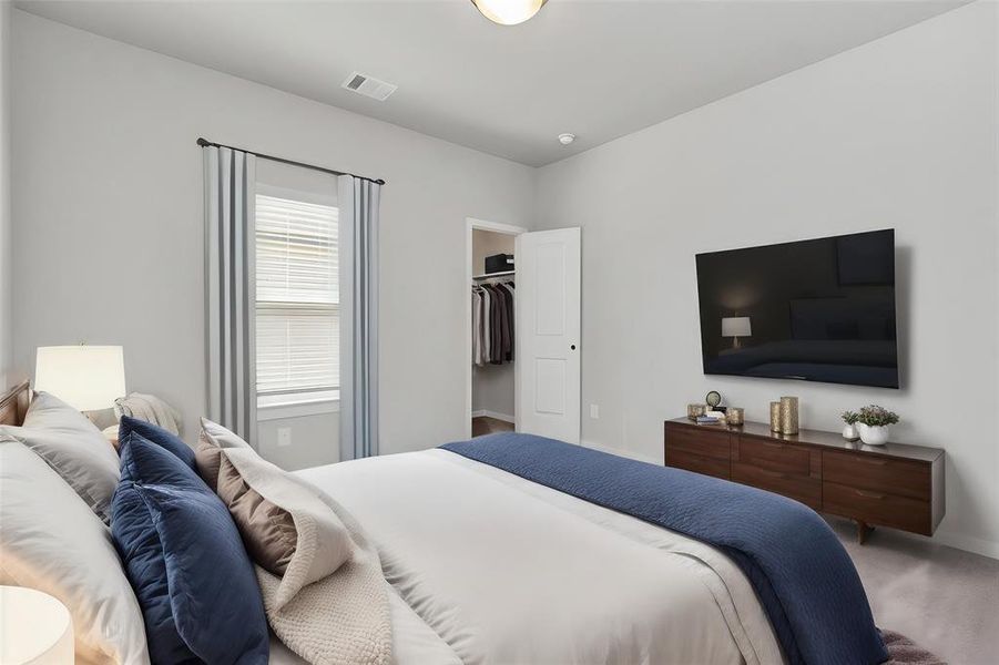 Relax and unwind in this cozy bedroom featuring soft, neutral tones and ample natural light. The room offers direct access to a spacious walk-in closet, providing convenience and extra storage. Whether you're starting your day or winding down, this tranquil space is designed for comfort and style, with clean lines and modern finishes that create a serene atmosphere. **This image is from another Saratoga Home with similar floor plan and finishes, not the June floorplan.**