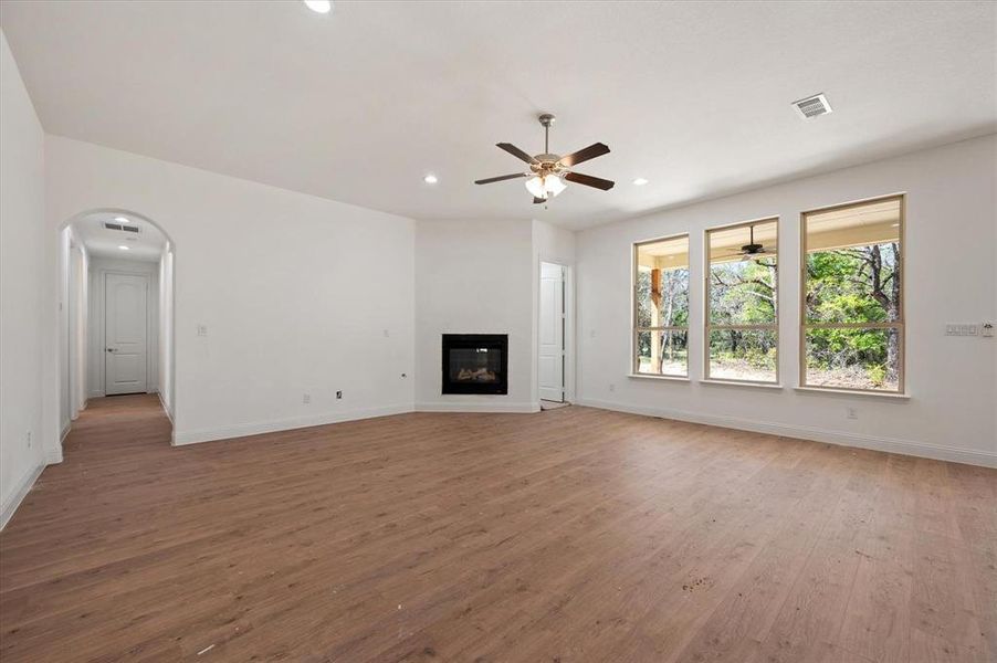 Unfurnished living room featuring light wood-type flooring and ceiling fan