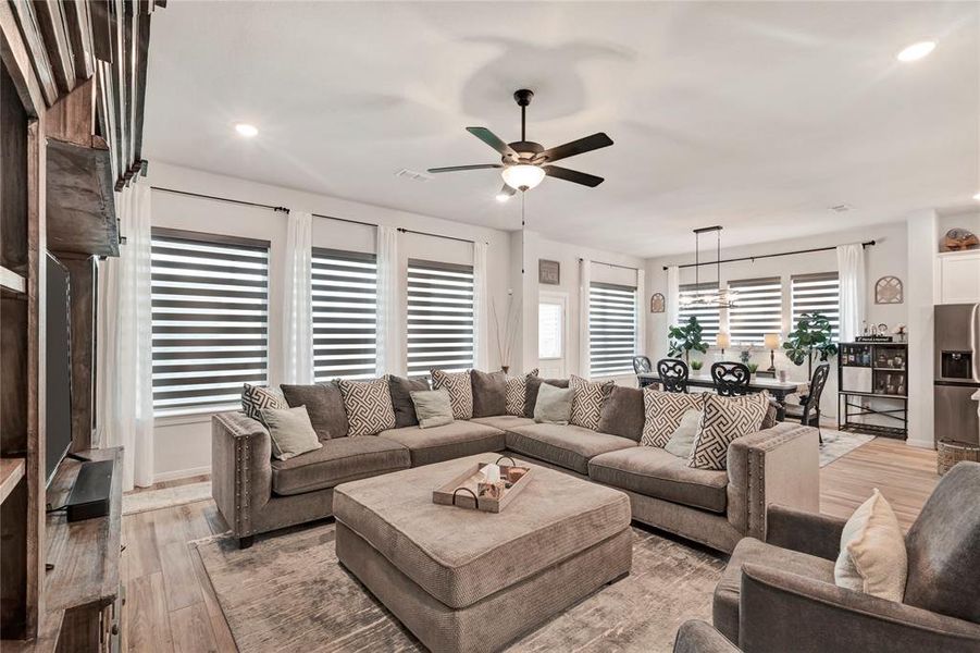 Bright and Open Living Room - Multiple windows provide plenty of natural light, with the dining area visible on the far right, creating an open and airy feel.