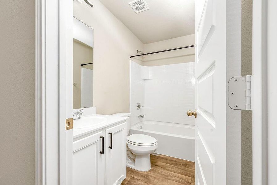 Full bathroom featuring shower / bathtub combination, hardwood / wood-style floors, toilet, and vanity