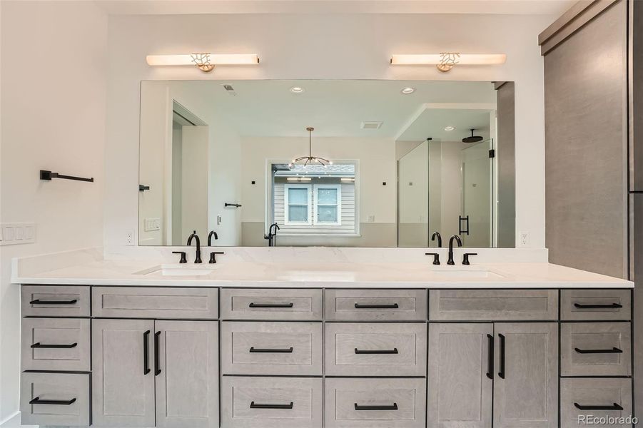 Spa inspired primary bath featuring free-standing soaking tub, multi-head shower, heated tile floors, dual vanities.