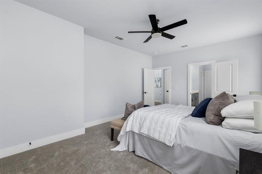 Bedroom featuring carpet, connected bathroom, and ceiling fan