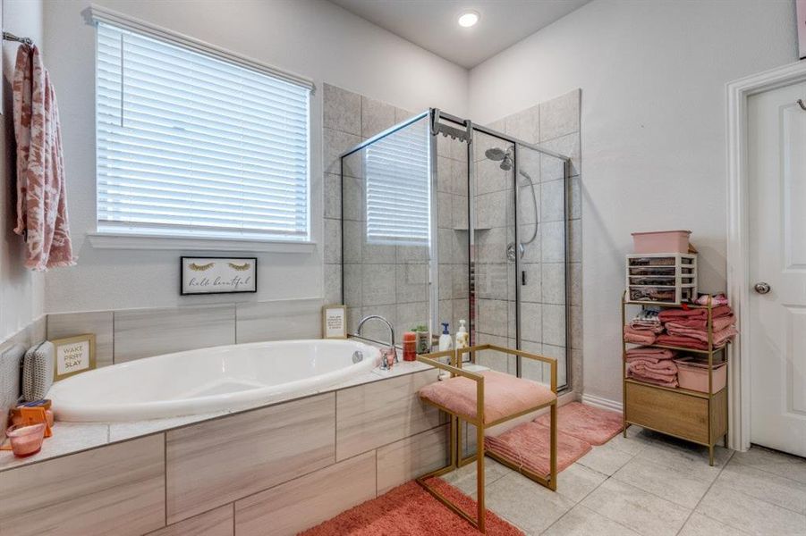 Bathroom featuring tile patterned flooring and shower with separate bathtub