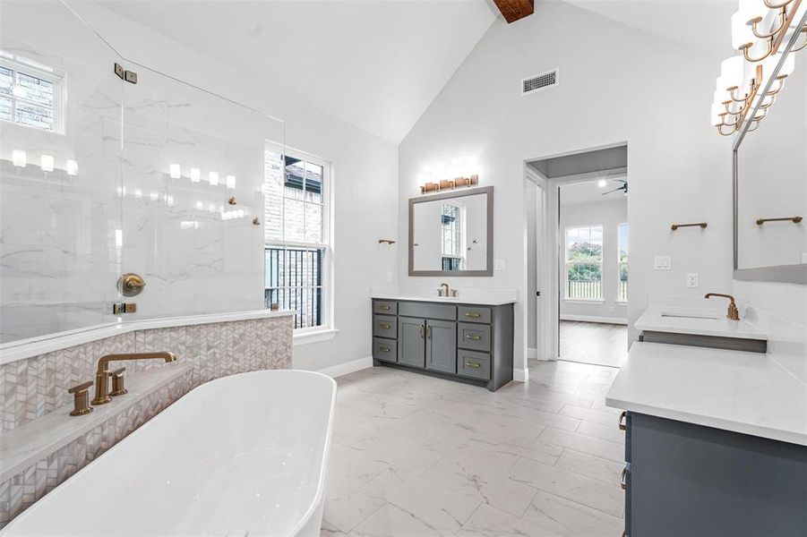 Bathroom featuring an inviting chandelier, dual bowl vanity, tile floors, beam ceiling, and high vaulted ceiling