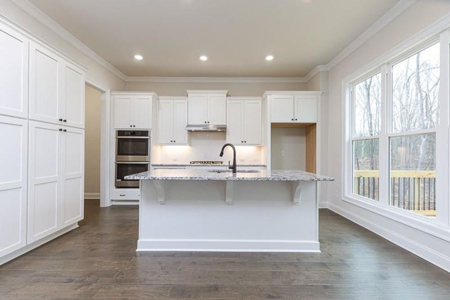 An oversized island overlooks the family room and provides the perfect spot for casual dining.  Photo not actual home, but previously built Mansfield plan.