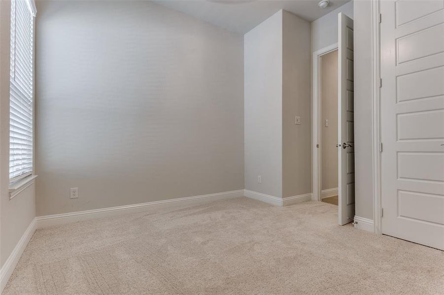 Unfurnished bedroom featuring light colored carpet