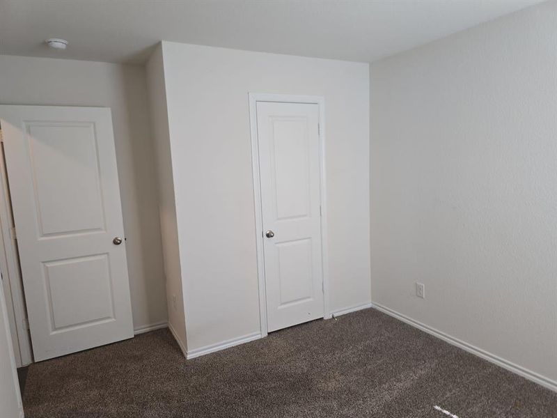 Unfurnished bedroom featuring dark carpet